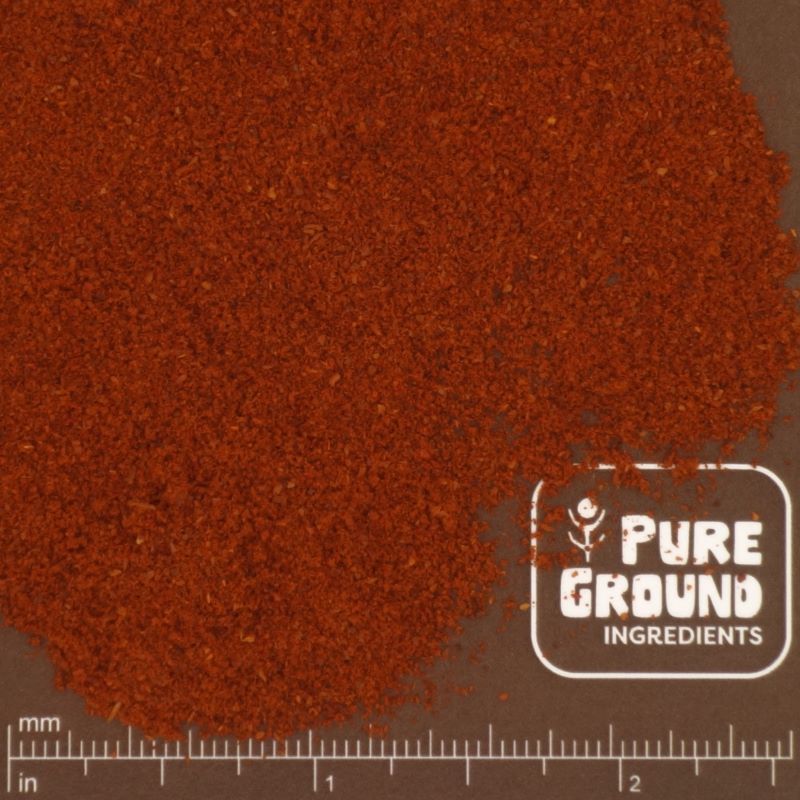 Close-up of red pepper powder with a 'Pure Ground Ingredients' logo and measurement scale.