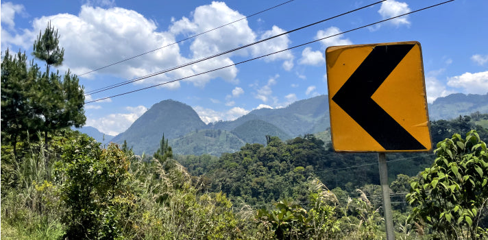 Road sign in front of landscape with mountains